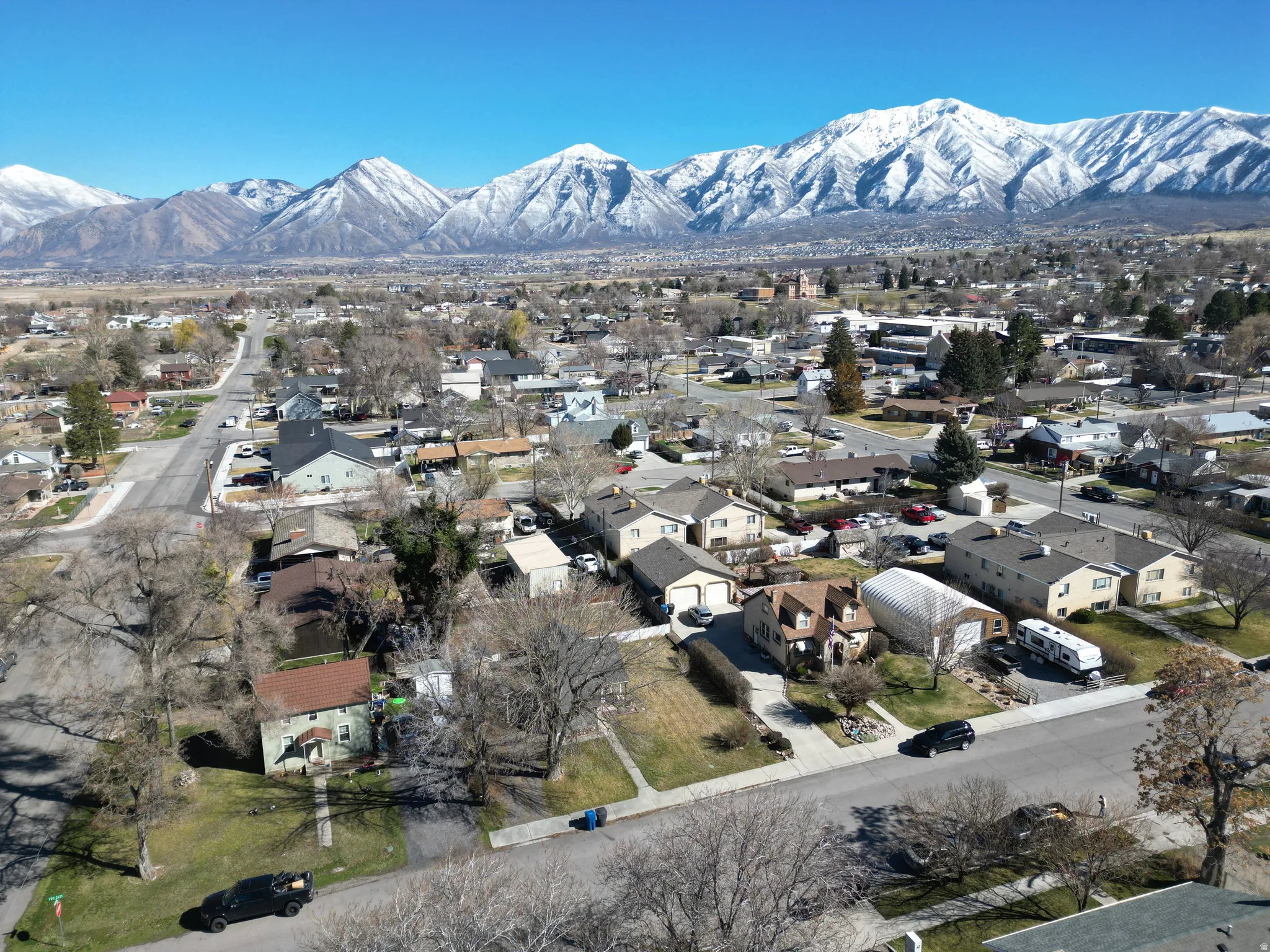 Aerial view of property's location with nearby suburban area and a mountainous background