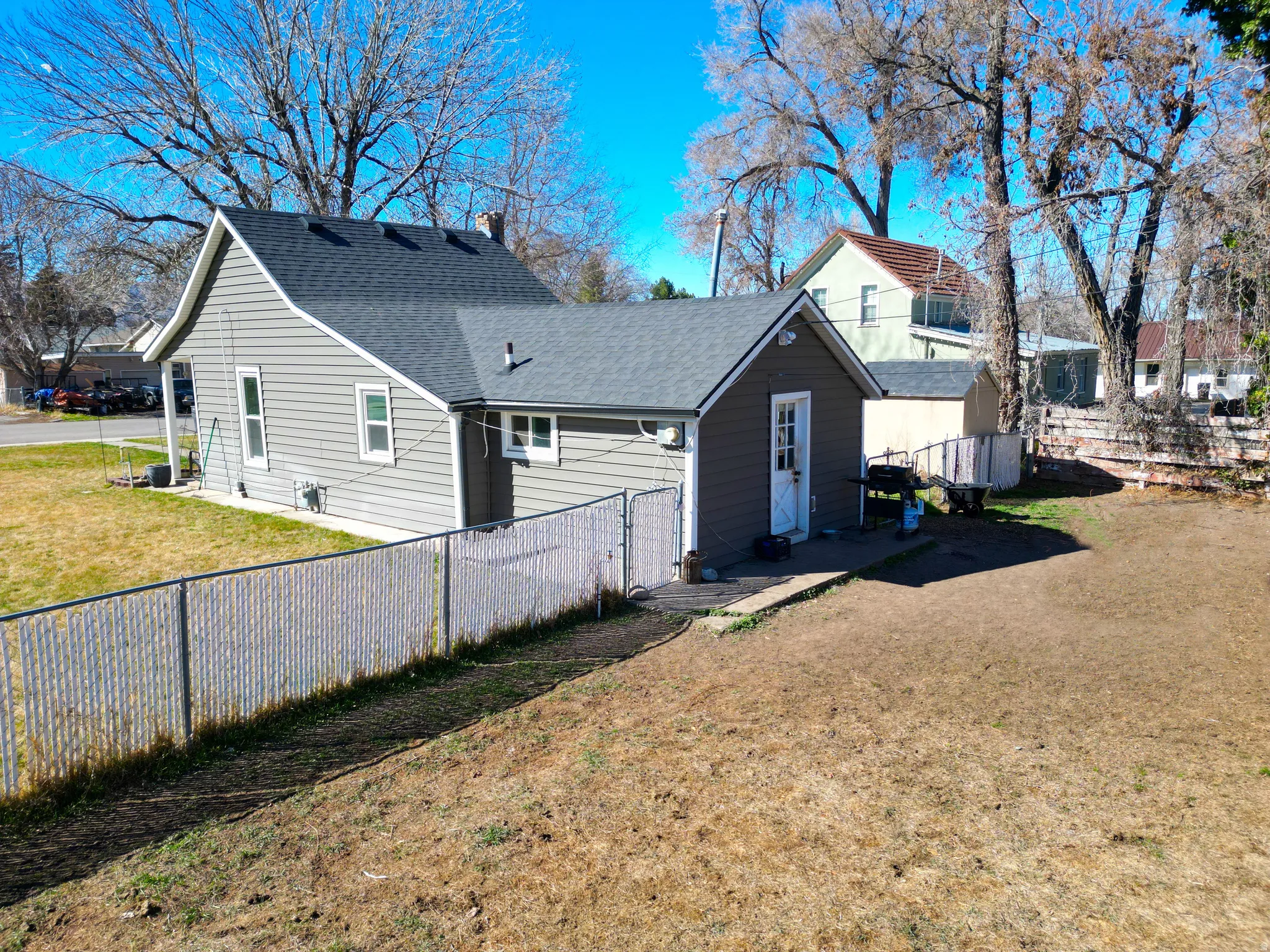 Rear view of house featuring a fenced backyard, roof with shingles, and a chimney