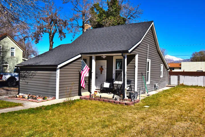 Bungalow with a porch, roof with shingles, and a chimney