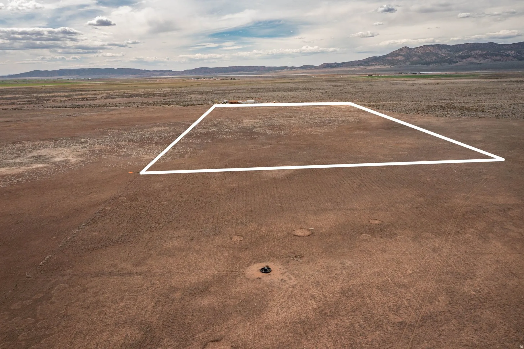 Aerial view of sparsely populated area with a mountainous background and property boundaries highlighted