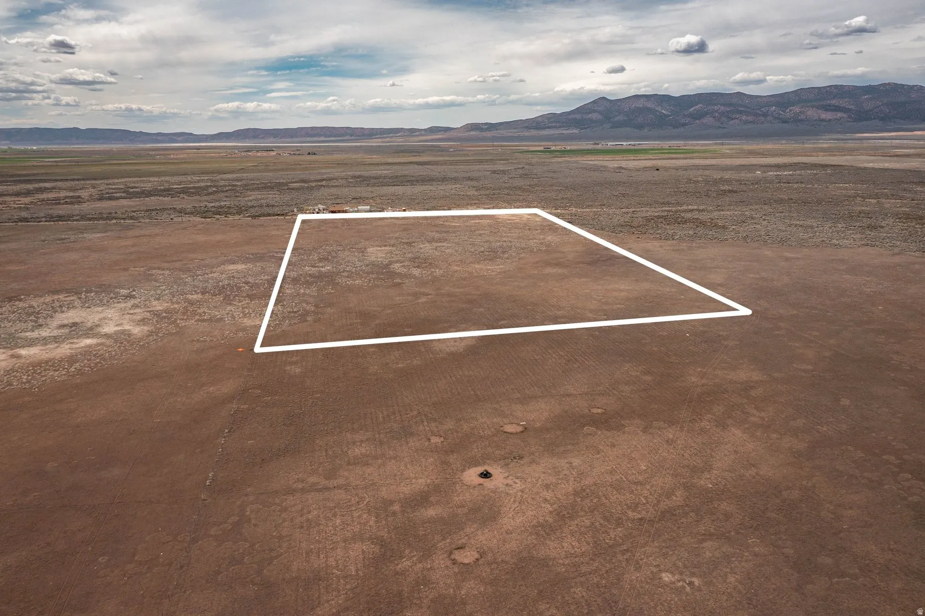 Overview of rural landscape with property boundaries highlighted and a mountainous background