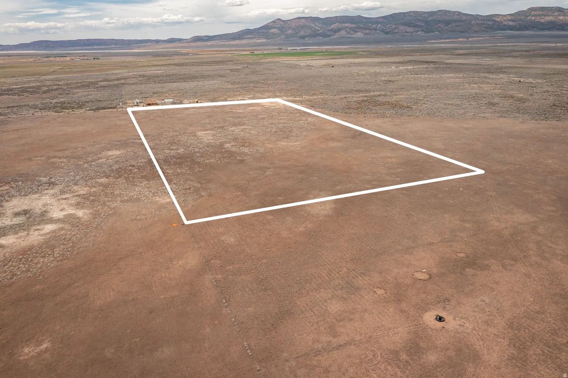 Aerial view of sparsely populated area with property boundaries highlighted and a mountain backdrop