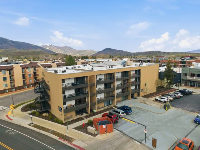 View of apartment building / complex featuring a mountain view and uncovered parking