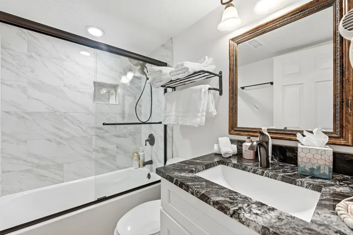 Full bathroom featuring vanity and shower / bath combination with glass door