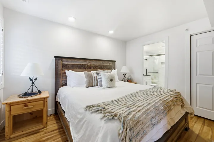 Bedroom featuring light wood-style flooring, ensuite bathroom, and recessed lighting