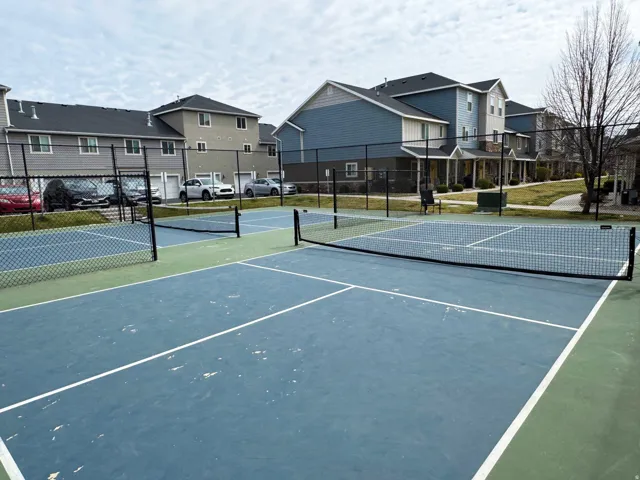 View of tennis court with a residential view