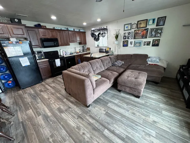 Living area featuring dark wood-style flooring, recessed lighting, and ceiling fan