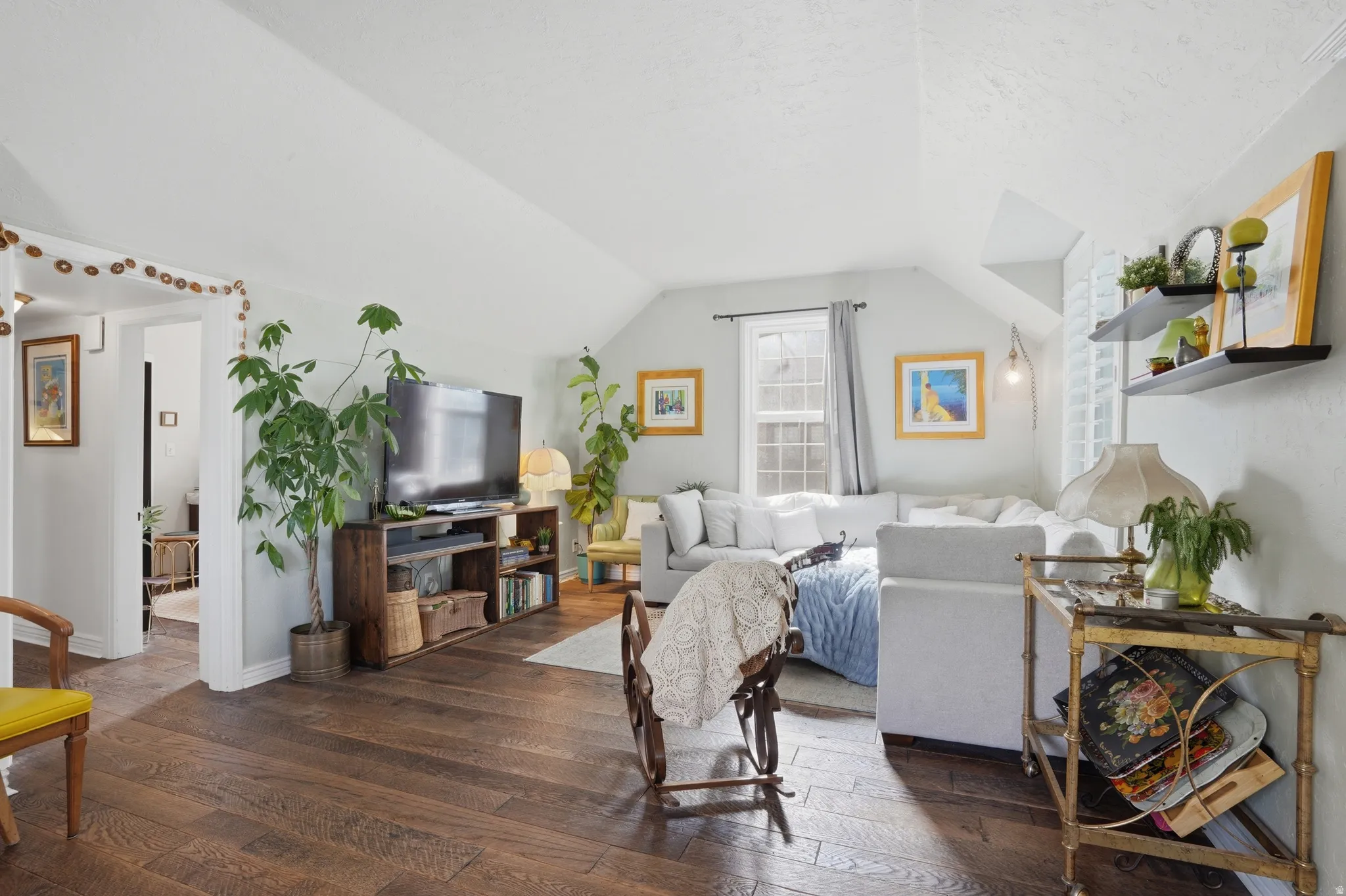 Living room with dark wood-style flooring and lofted ceiling
