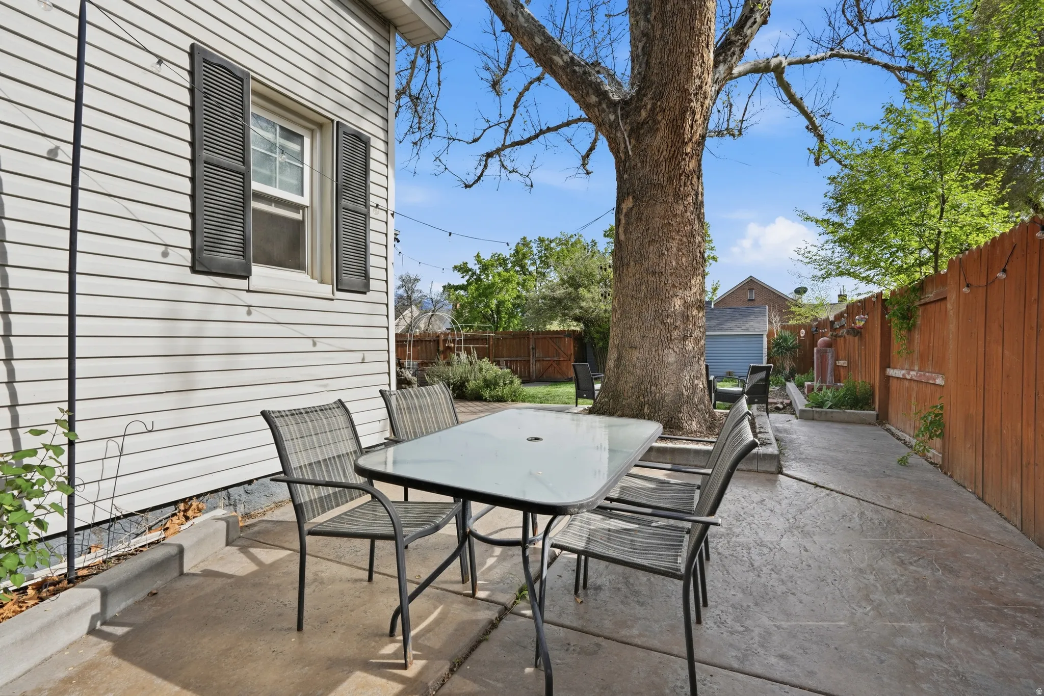 Fenced backyard with outdoor dining area and a patio