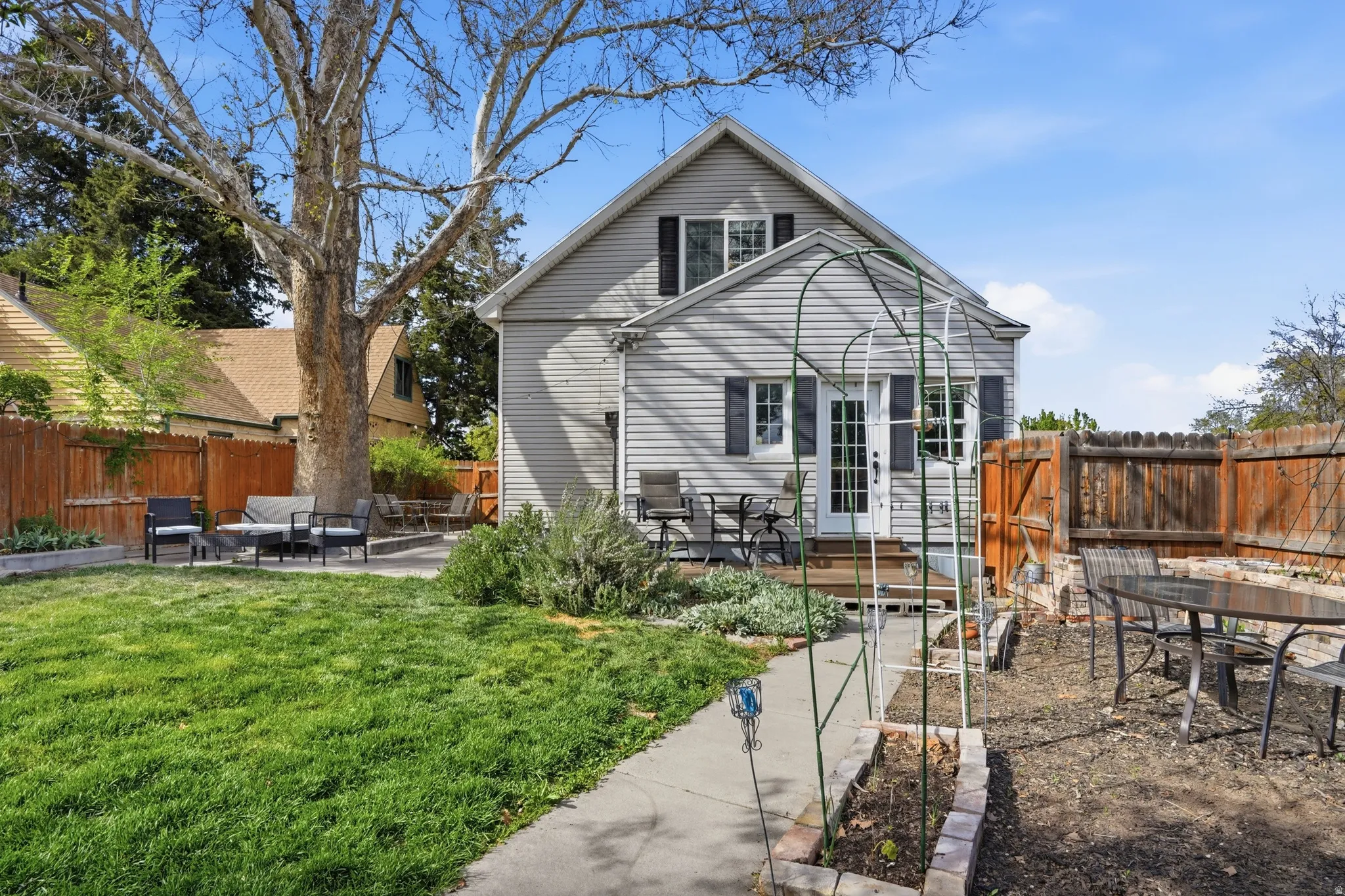 Rear view of property featuring a patio area, outdoor dining space, and a fenced backyard