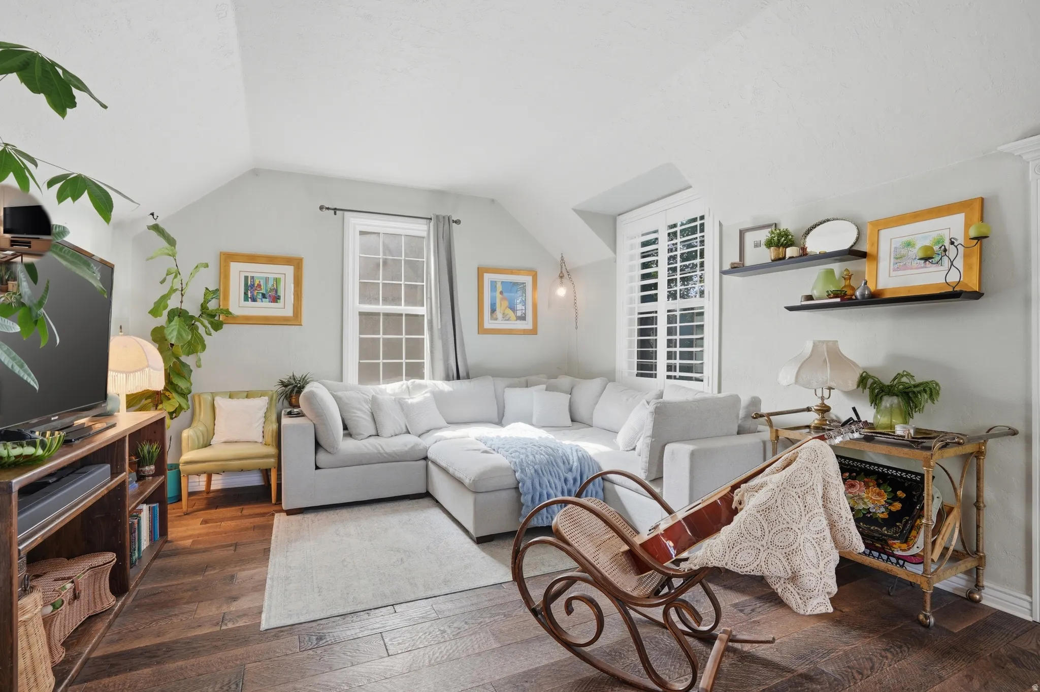 Living area with hardwood / wood-style floors and lofted ceiling