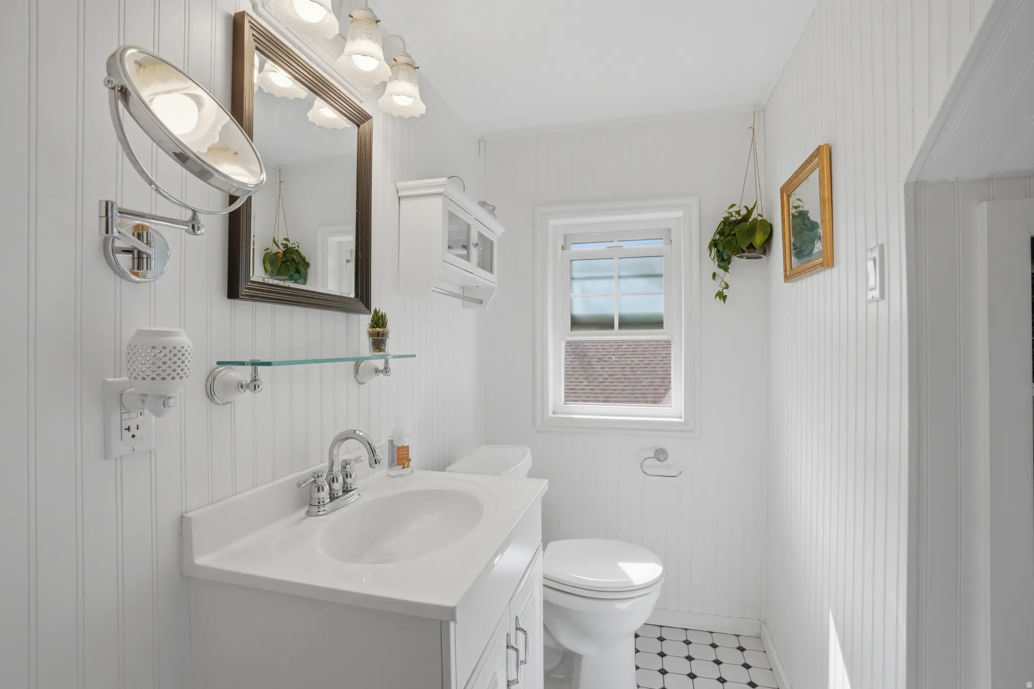 Bathroom featuring vanity, light flooring, and wood walls