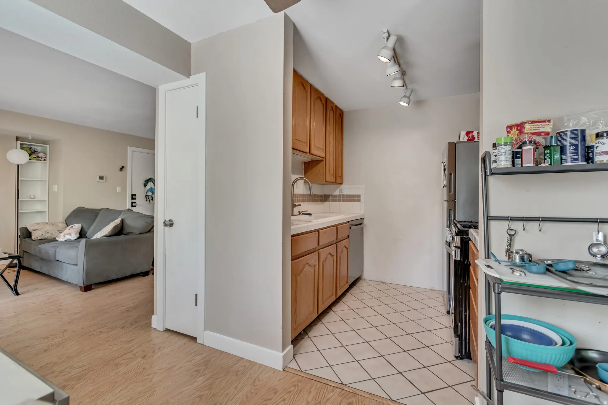 Kitchen featuring light countertops, stainless steel appliances, open floor plan, decorative backsplash, and light wood-style floors