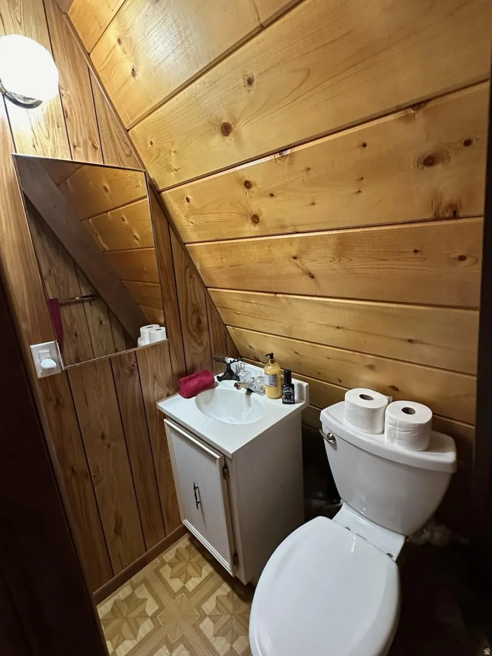 Bathroom with vanity, wood walls, and a vaulted wooden ceiling