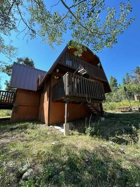 View of side of home featuring a deck and a metal roof