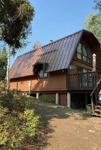 Back of property featuring a deck and a standing seam roof