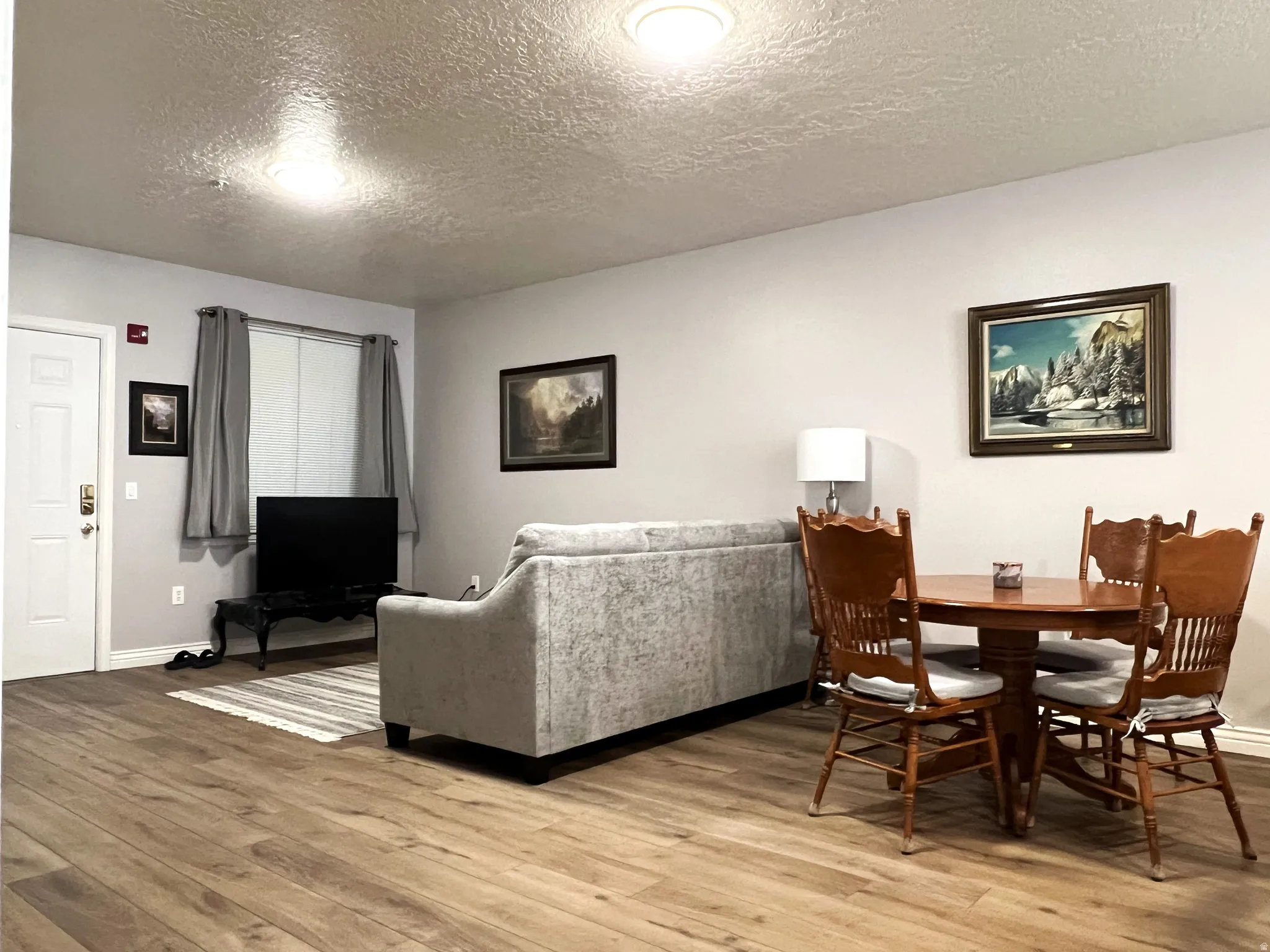 Dining space with a textured ceiling and light wood finished floors