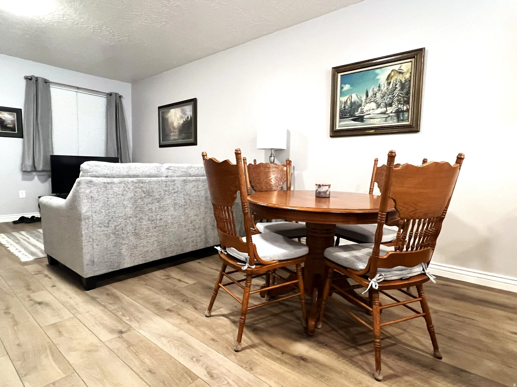 Dining space featuring a textured ceiling and light wood finished floors