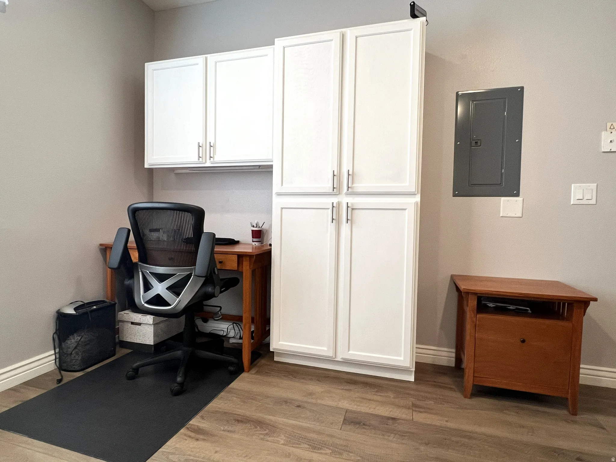 Office space featuring electric panel and wood finished floors
