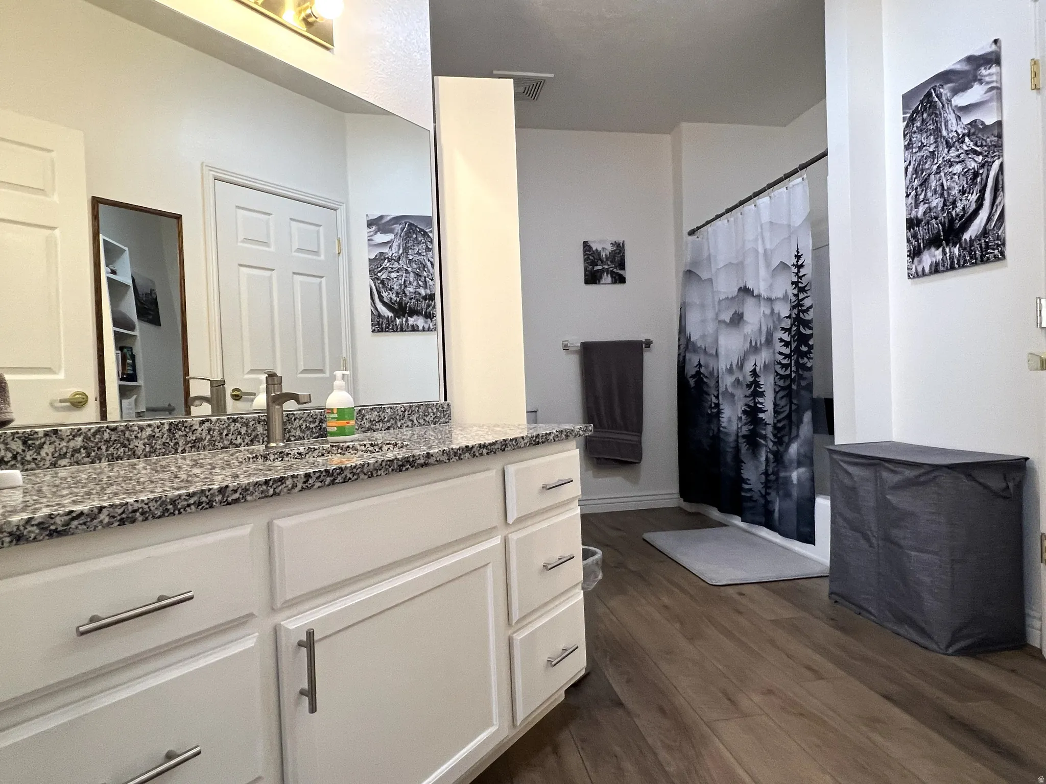 Full bath featuring a shower with shower curtain, vanity, and dark wood finished floors