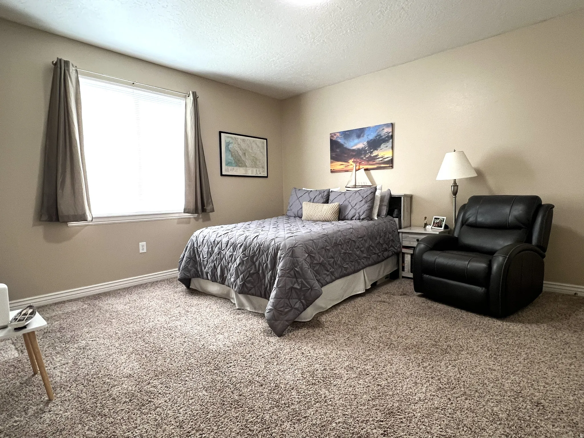 Extra Large Carpeted bedroom with baseboards and a textured ceiling