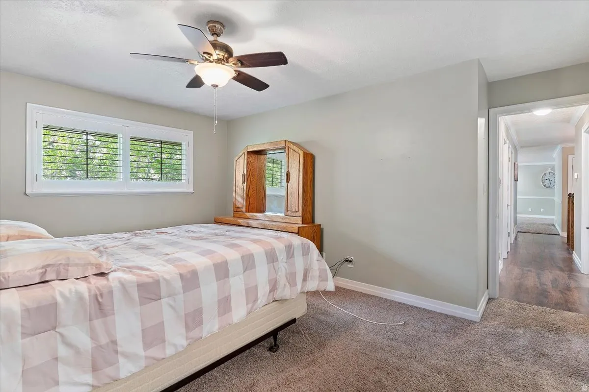 Carpeted bedroom featuring baseboards and ceiling fan