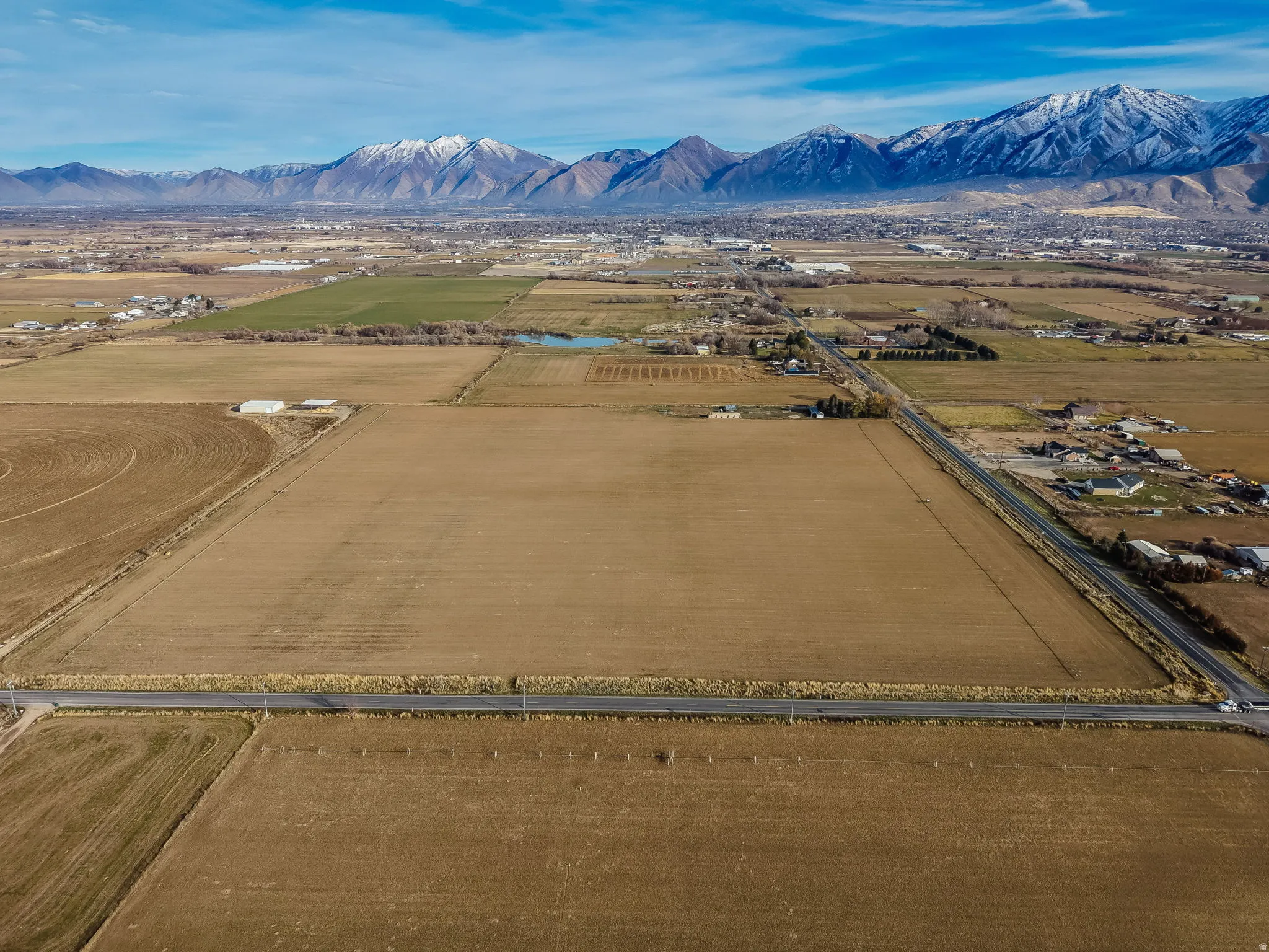 Overview of rural landscape featuring a mountain backdrop and extensive farmland