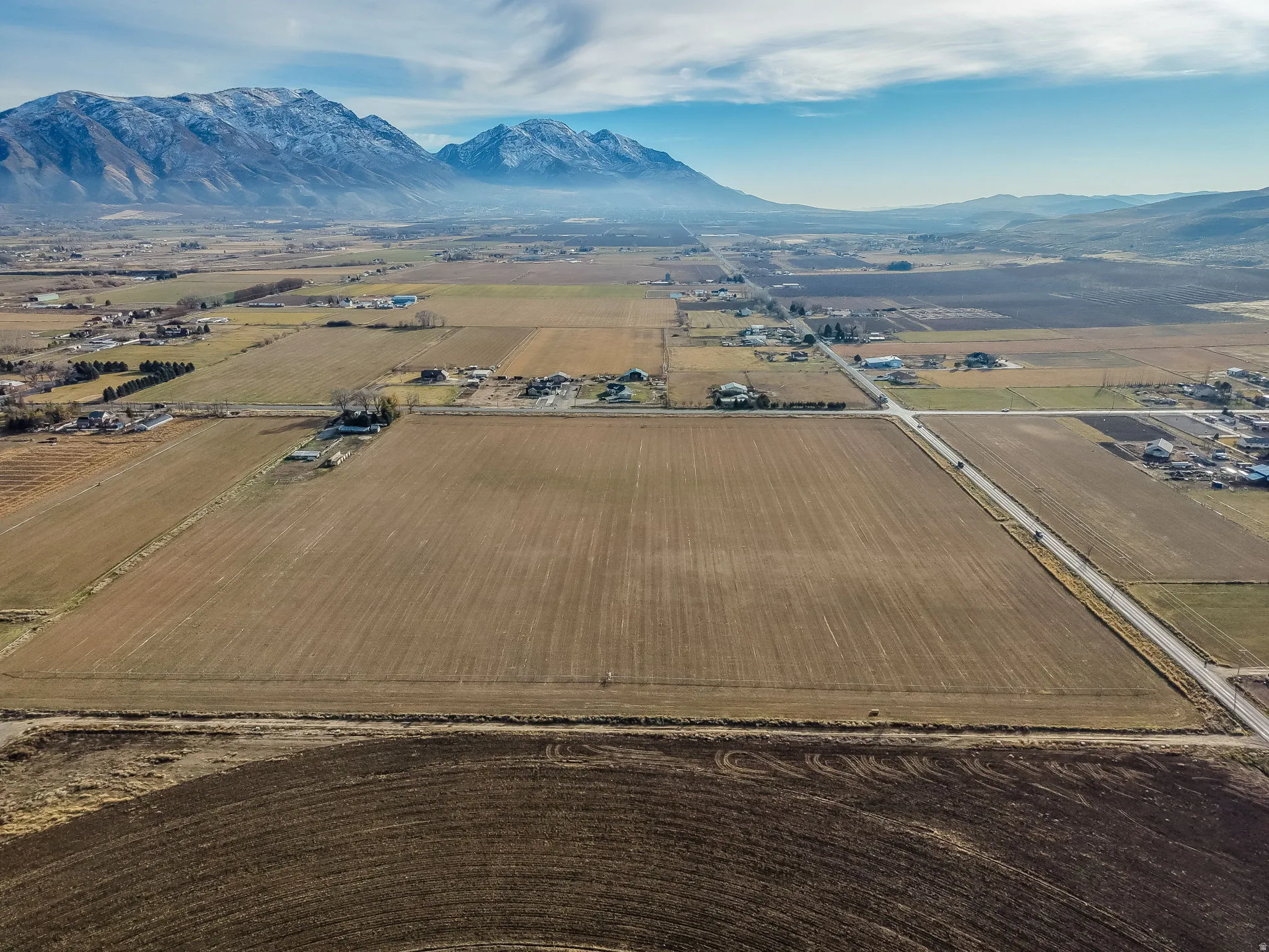 Overview of rural landscape featuring a mountainous background and farmland