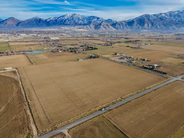 View of rural area featuring a mountainous background and rows of crops
