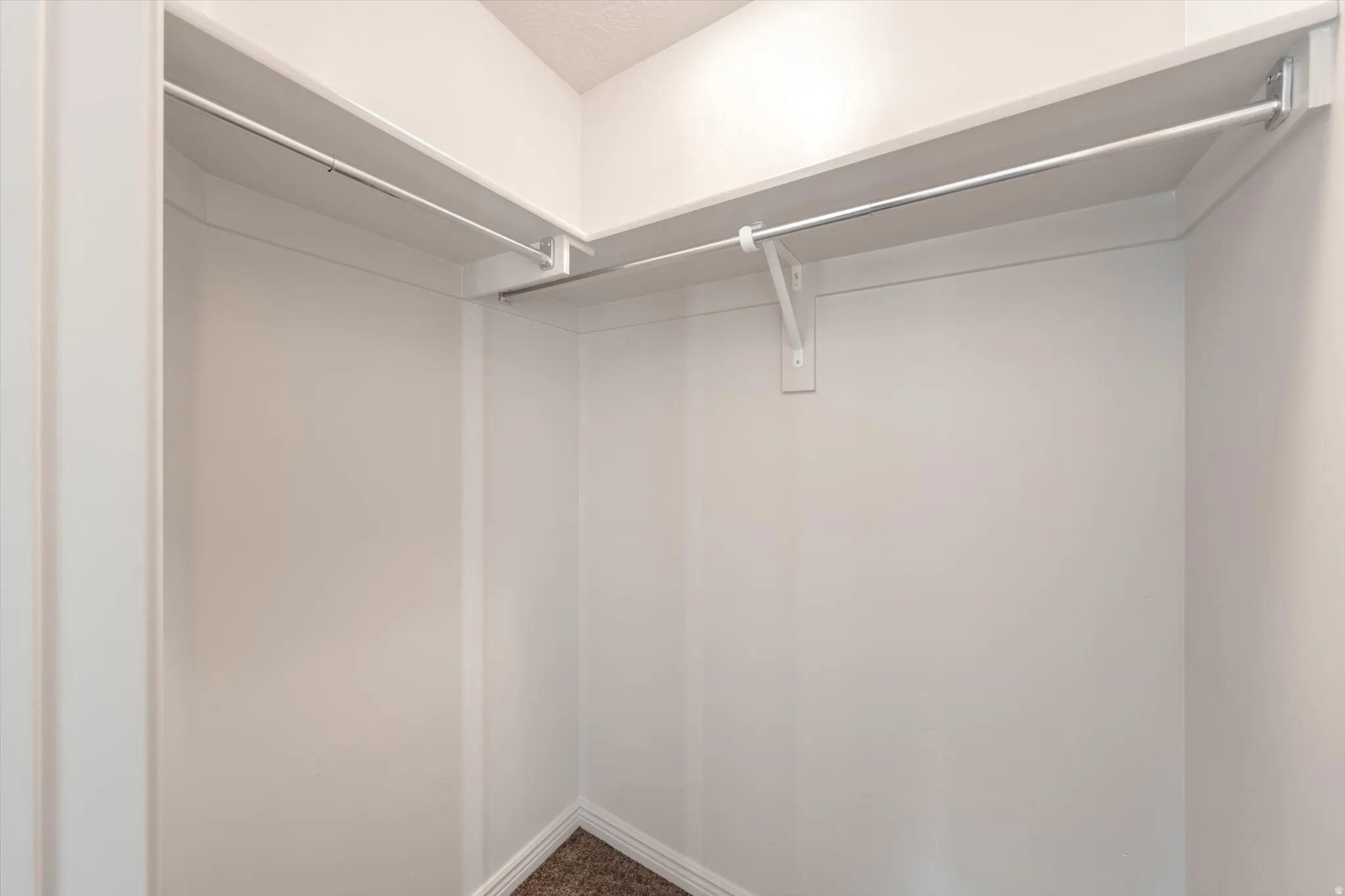Walk in closet featuring dark carpet