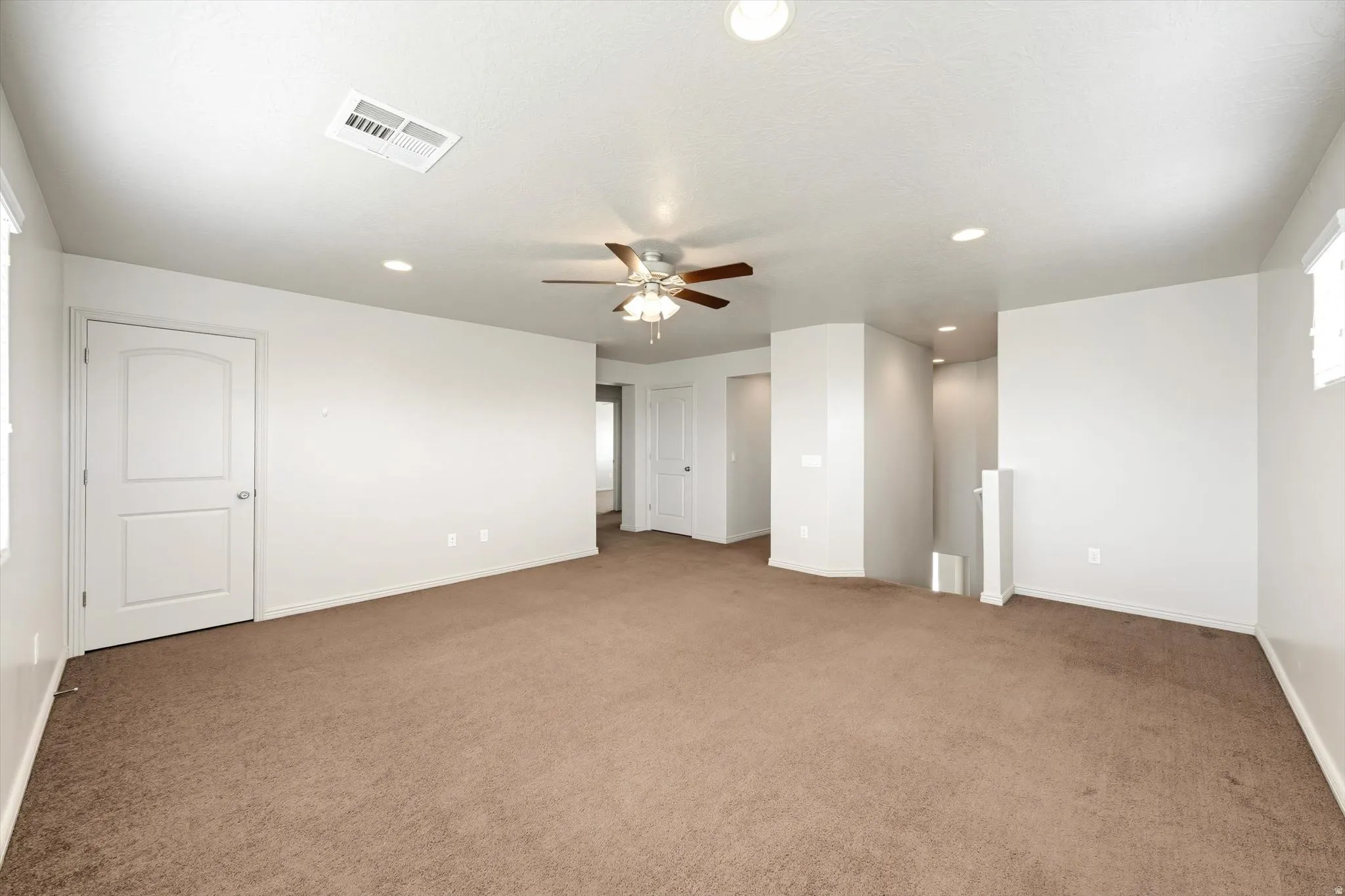 Empty room featuring recessed lighting, ceiling fan, and light colored carpet