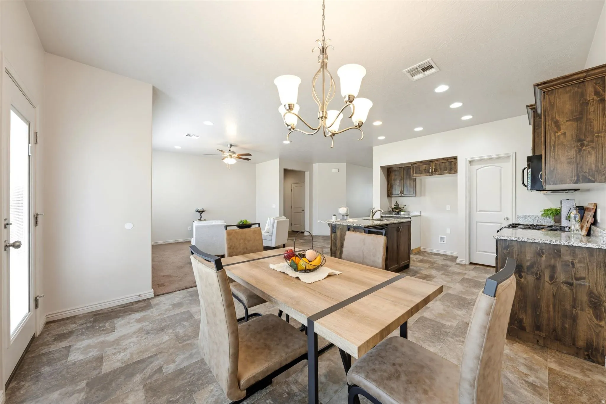 Dining space featuring suspended lighting, stone finish floors, and ceiling fan
