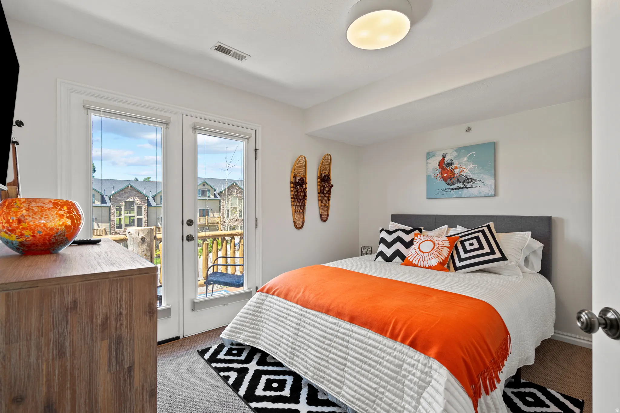 Bedroom featuring french doors, light carpet, and access to outside deck