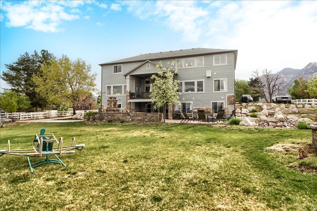 Back of property with a patio, a balcony, and a mountain view