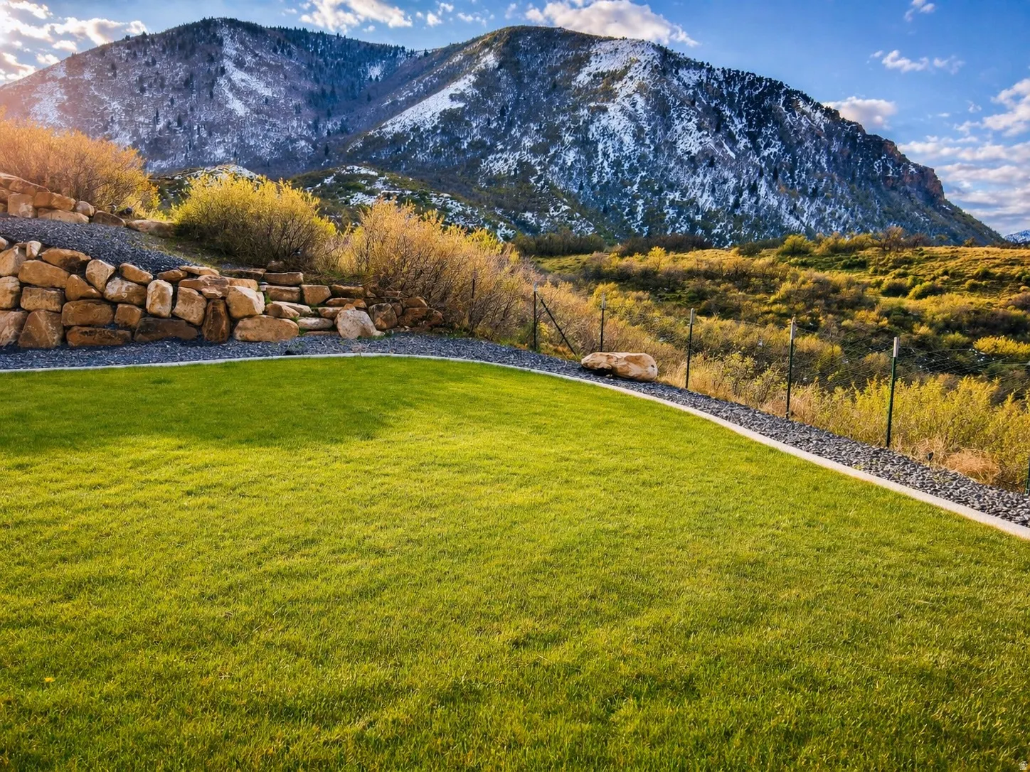 Lush green lawn with a decorative gravel border