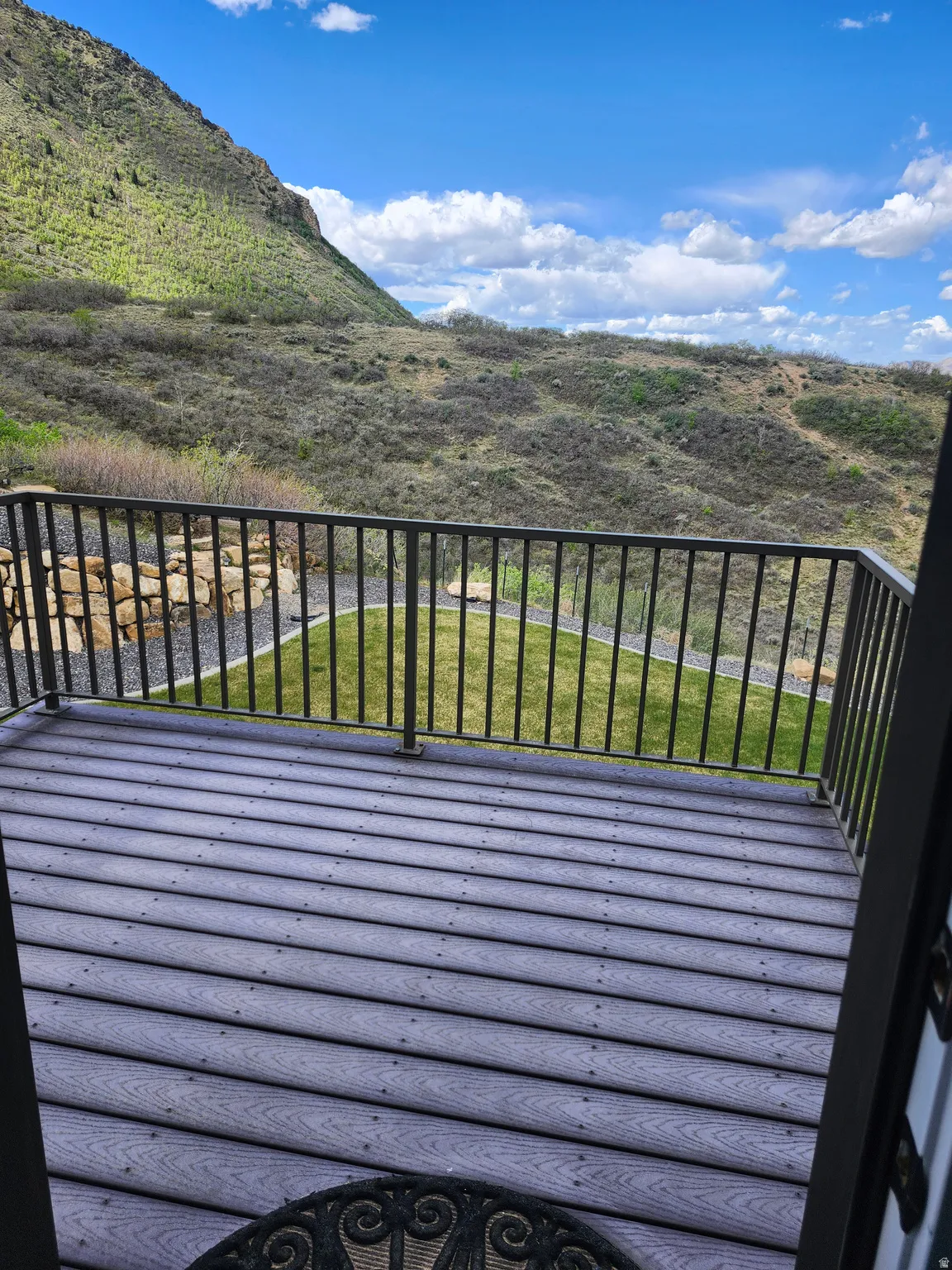 Spacious outdoor deck featuring composite decking and black metal railings