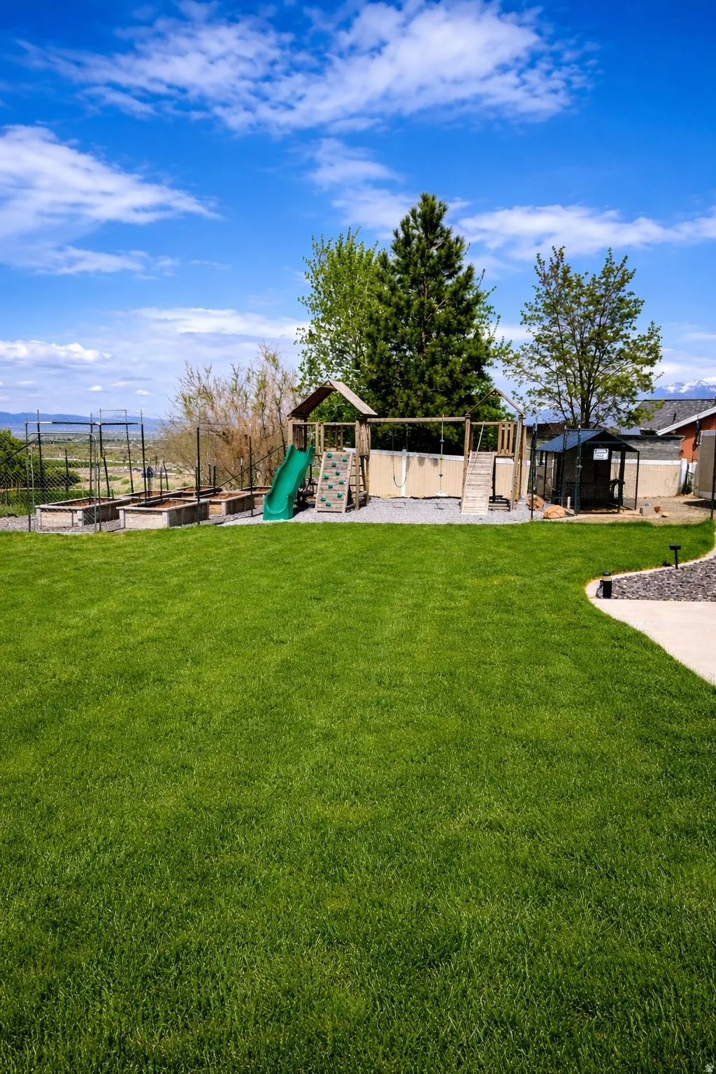 Expansive lawn area featuring a paved walkway with dark stone edging