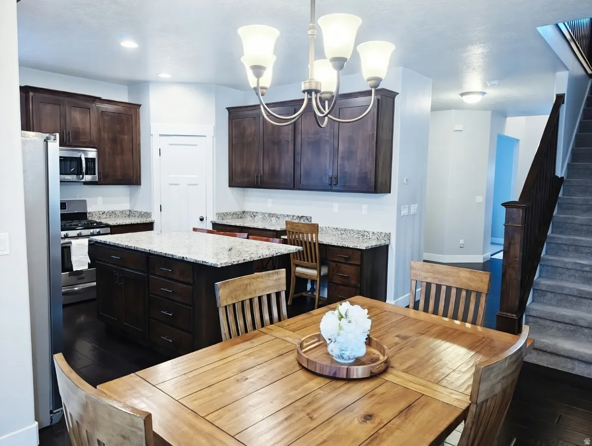 Kitchen featuring dark wood cabinetry, granite-style countertops, and stainless steel appliances