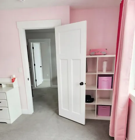 Room featuring light pink walls, light gray carpet, and white trim