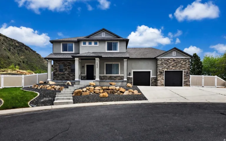 Contemporary two-story residence featuring a gray stucco and stone facade
