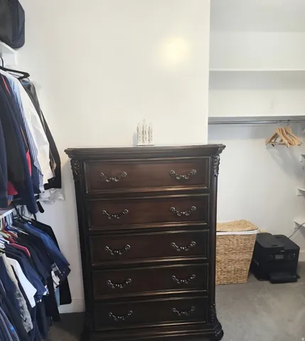 Integrated closet system featuring white shelving and hanging rods