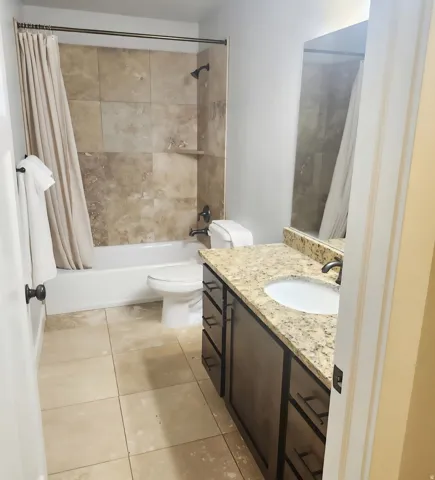 Bathroom featuring a vanity with granite-style countertop, integrated sink, and dark wood-finish cabinetry with multiple drawers