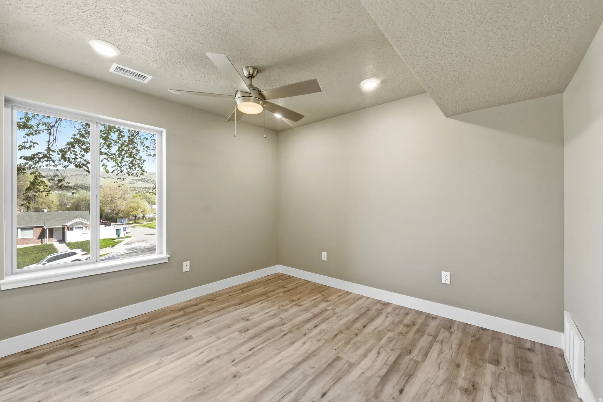 Unfurnished room featuring light wood-style floors, ceiling fan, a textured ceiling, and recessed lighting
