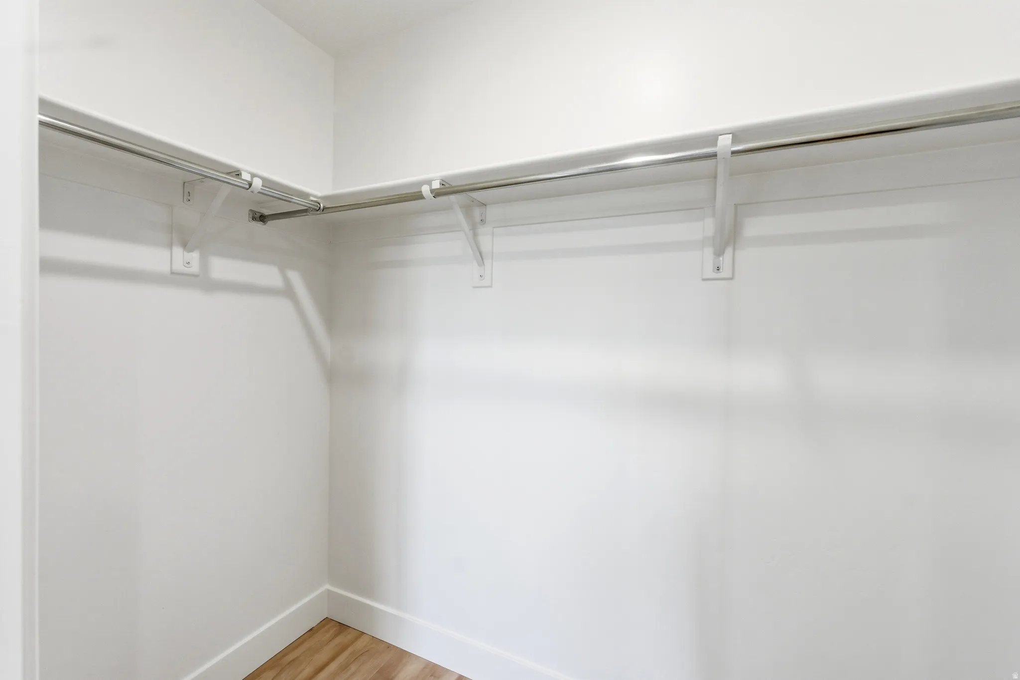 Walk in closet with light wood-style floors
