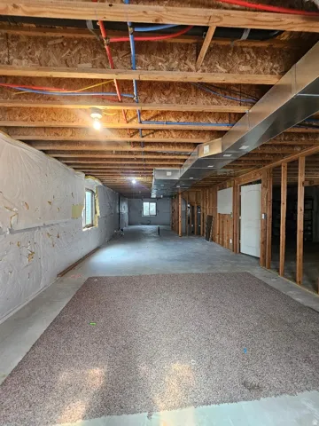 Basement Spacious unfinished lower level featuring exposed wood joists, visible plumbing lines, and ductwork