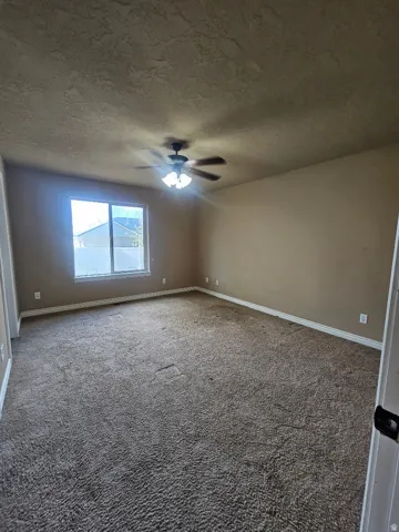 Master Bedroom Spacious room featuring broadloom carpet, a large window, a ceiling fan with integrated lighting, and neutral wall paint