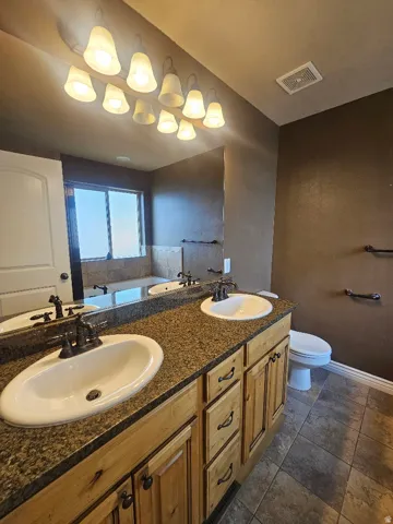 Master Bath Double vanity with an integrated mirror and extensive lighting fixture