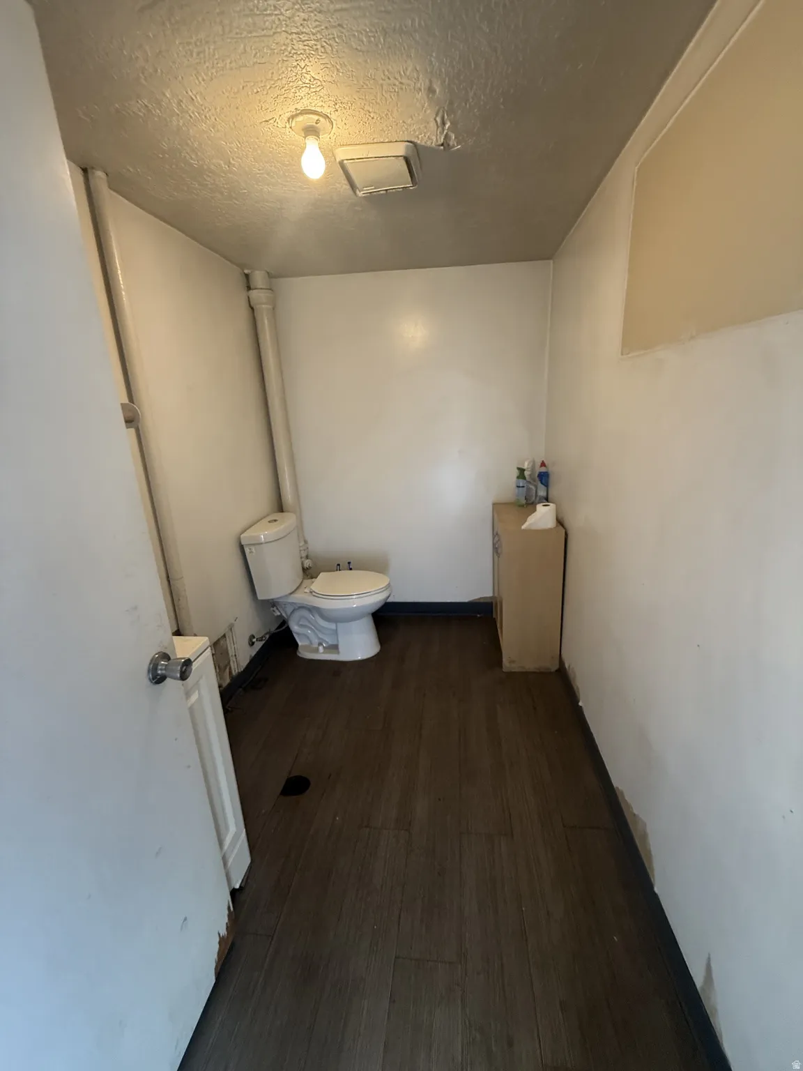 Bathroom featuring dark wood-style flooring and a textured ceiling