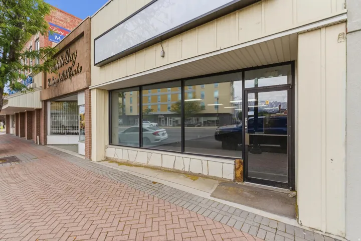 Ground-level commercial storefront featuring large display windows and a glass entry door