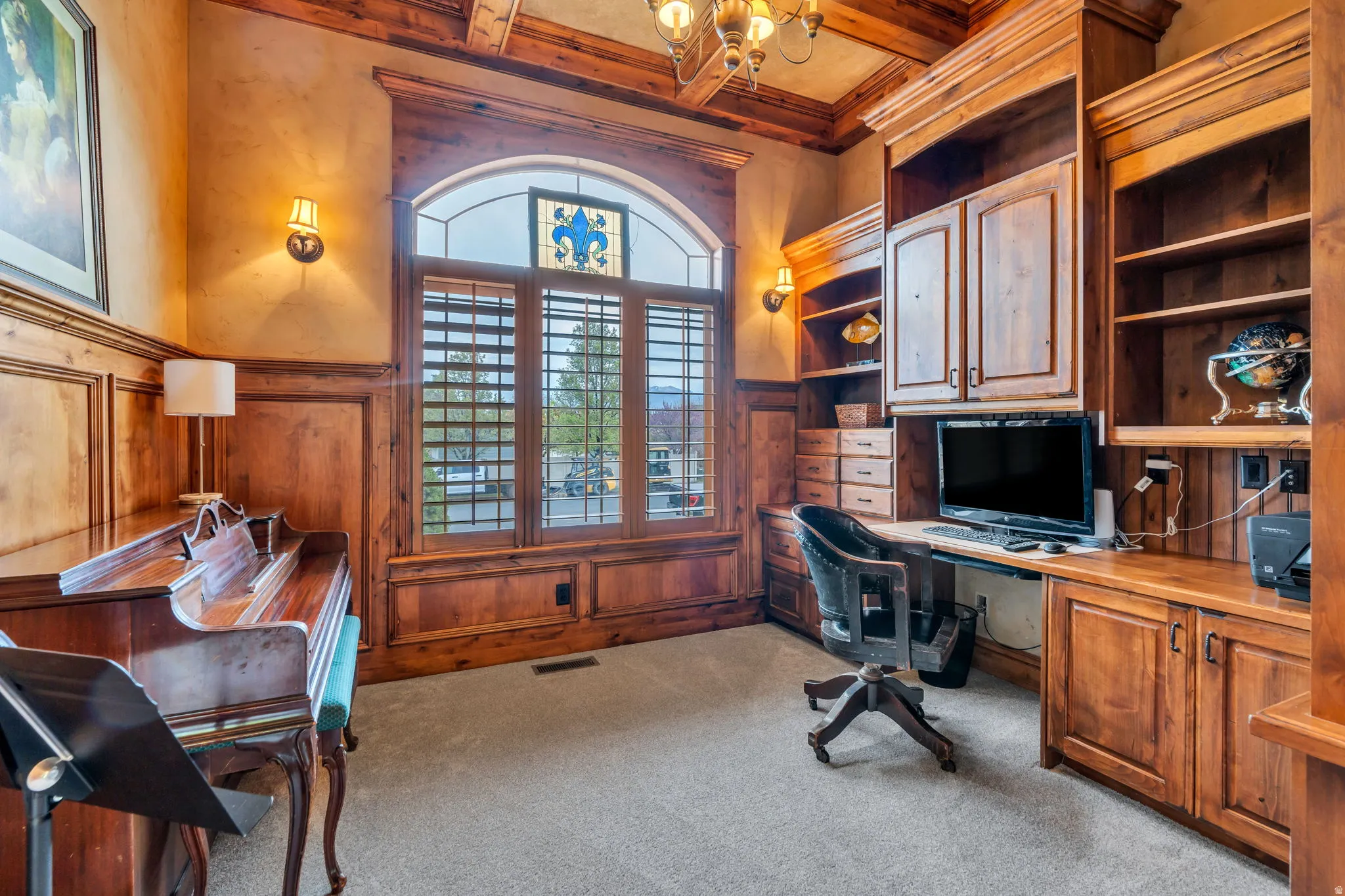 Home office featuring coffered ceiling, suspended lighting, built in study area, light carpet, and built in features